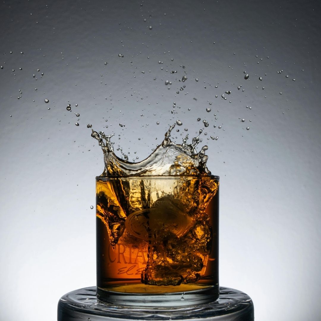 Whiskey on the rocks with ice splash in a glass at Burke's Public House